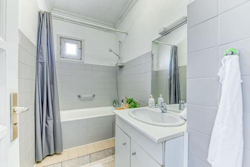 y baño blanco con lavabo y bañera. en L'élégant Zola, en Villeurbanne