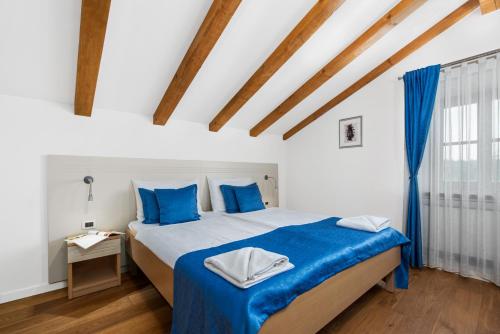 a bedroom with a large bed with blue pillows at Pilato in Vižinada
