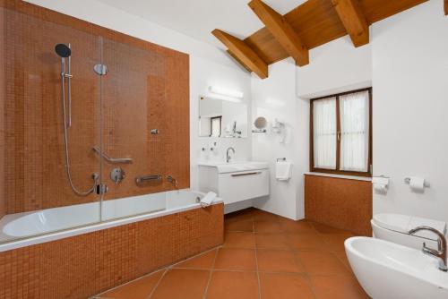 a bathroom with a tub and a shower and a sink at Pilato in Vižinada