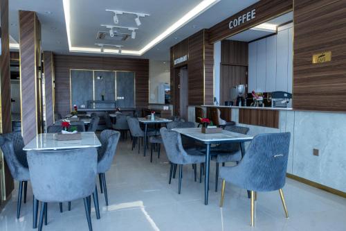 un ristorante con tavoli, sedie e bancone di أزهار النرجس للشقق الفندقية a Umm al Khashab