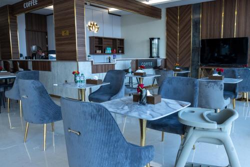 een eetkamer met blauwe stoelen en tafels bij أزهار النرجس للشقق الفندقية in Umm al Khashab