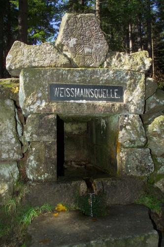 a sign on top of a stone wall at Hotel Kaiseralm in Bischofsgrün