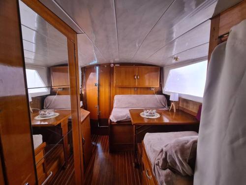 a room with two beds and a table in a boat at Bateau in Ouistreham