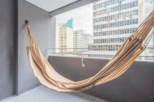 a hammock in a balcony with a view of a city at Tabas - Edifício União Continental in Sao Paulo