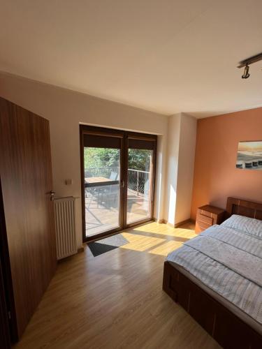 1 dormitorio con 1 cama y puerta corredera de cristal en Apartament nad Zatoką Pucką, en Władysławowo