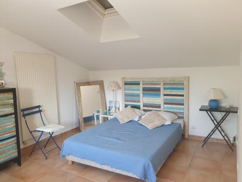 Maison Parc Ducup في بيربينيا: غرفة نوم بسرير ازرق ومرآة