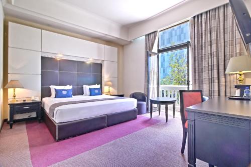 a hotel room with a large bed and a desk at Hotel Imperial Reforma in Mexico City