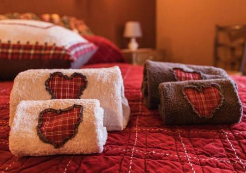 Una cama roja con dos almohadas con corazones. en Ca d'Moreno en Viù