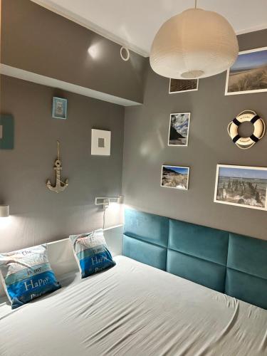 a bedroom with a bed with a blue headboard at Apartament Przy Lesie in Międzywodzie