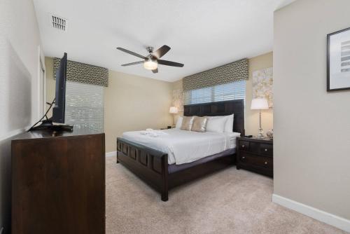een slaapkamer met een bed en een flatscreen-tv bij House with pool in a resort in Kissimmee