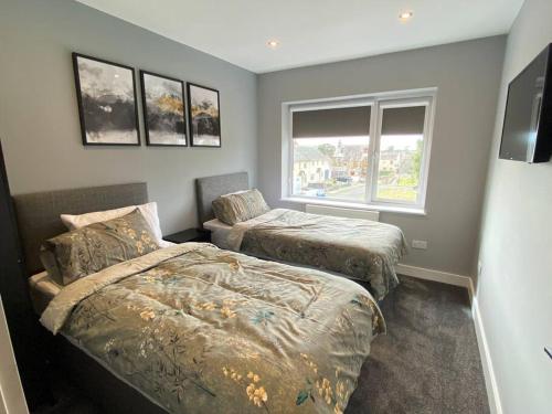 1 dormitorio con 2 camas y ventana en A modern, dog-friendly 3 bedrm canal side property en Bolton le Sands