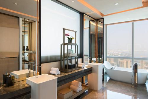 a bathroom with a tub and a sink and a bath tub at Shenzhen Marriott Hotel Nanshan in Shenzhen