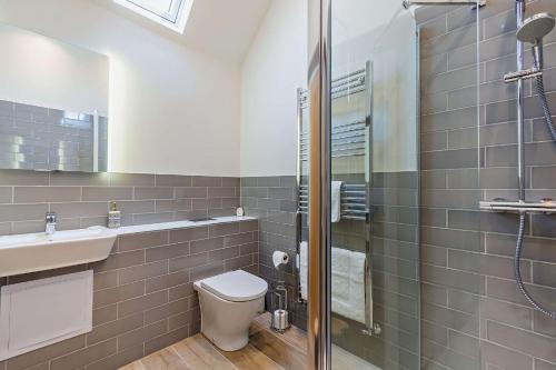 a bathroom with a toilet and a sink and a shower at Dairy Barn by Bloom Stays in Groombridge