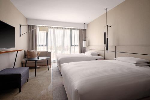 Habitación de hotel con 2 camas y TV de pantalla plana. en Tunis Marriott Hotel, en Túnez