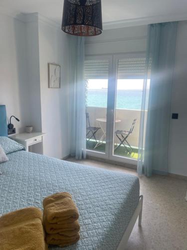 a bedroom with a bed and a view of the ocean at VISTAS ROCA MAR in La Línea de la Concepción
