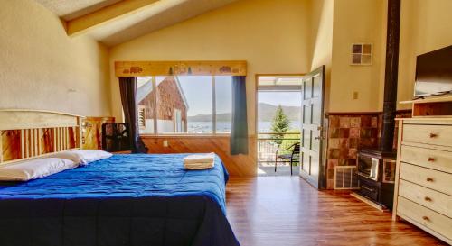 a bedroom with a blue bed and a large window at Lakefront Escape in Big Bear Lake