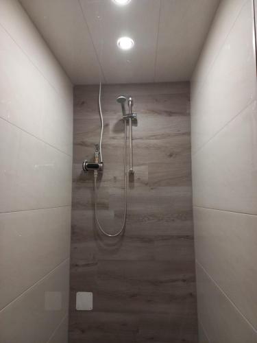 y baño con ducha y pared de madera. en hoteliving Duisburg-Moers, en Duisburg