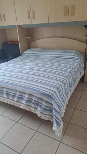 uma cama com um cobertor azul e branco em CONDOMINIO MAURIZIO A MARE em Scerne