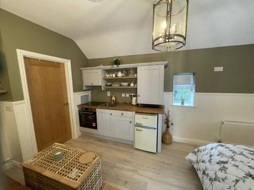 a kitchen with white cabinets and a table in a room at Toddys Cottage & Stables in Cavan