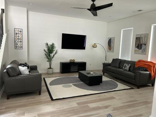 a living room with two couches and a flat screen tv at Atlanta Elegance in Atlanta