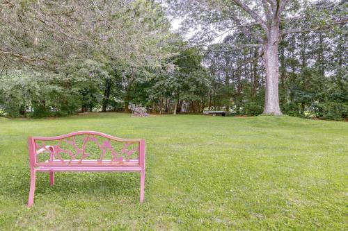 a pink bench sitting in the grass in a park at Coventry Lake Getaway with Yard Near UConn! in Coventry