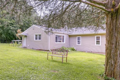 a house with a bench in front of a yard at Coventry Lake Getaway with Yard Near UConn! in Coventry