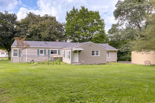 a house in a yard with a grassy field at Coventry Lake Getaway with Yard Near UConn! in Coventry