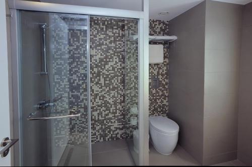 a bathroom with a glass shower with a toilet at Okeanos Beach Boutique Hotel in Ayia Napa