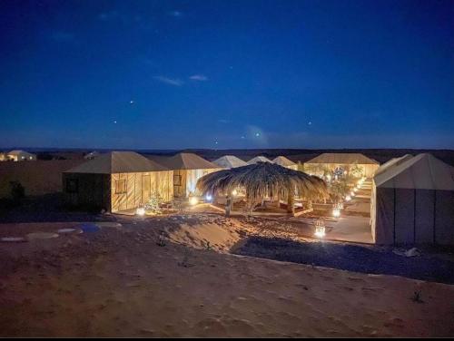un gruppo di tende nel deserto di notte di Sahara Nomad Camp a Merzouga