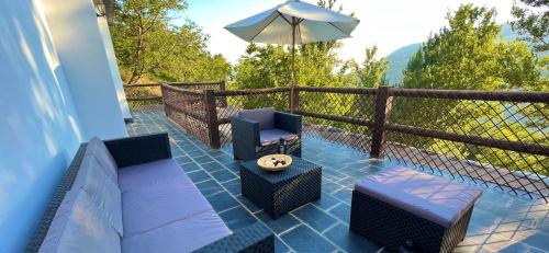 a patio with two chairs and an umbrella at Terraza de Poqueira in Capileira