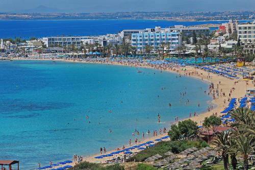 a beach with a bunch of people in the water at Okeanos Beach Boutique Hotel in Ayia Napa