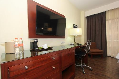 a hotel room with a dresser with a television on the wall at Holiday Inn Leon by IHG in León