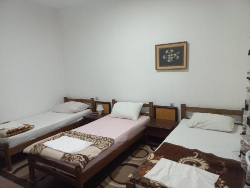 een groep van drie bedden in een kamer bij Apartmani Lovčević in Bogatić