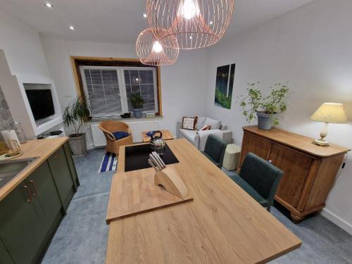 a kitchen with a wooden table and a living room at Apartment Emilia in Świdnica
