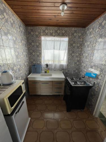 uma pequena cozinha com um fogão e um lavatório em VIRAMAR en Alvorada em Barra del Chuy