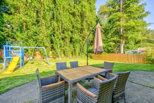 a table and chairs with an umbrella and a playground at Cheerful Kirkland Home w&AC Big Yard,Walk to Beach in Kirkland