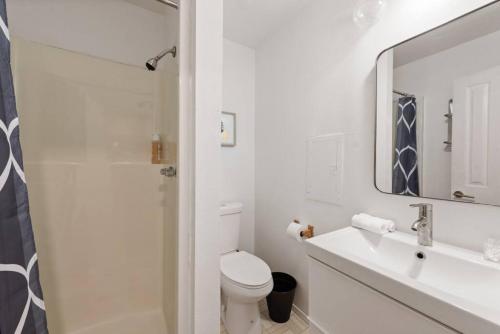 a bathroom with a toilet and a sink and a mirror at Cheerful Kirkland Home w&AC Big Yard,Walk to Beach in Kirkland