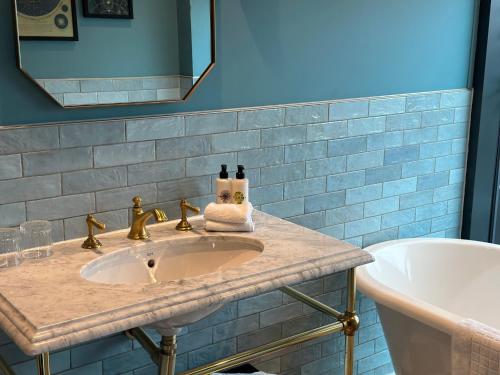a bathroom with a sink and a tub at Hotel Indigo - Exeter by IHG in Exeter