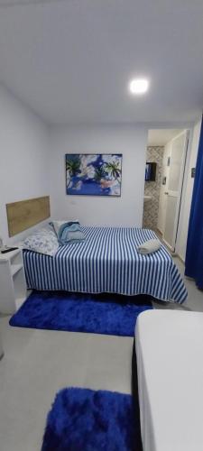 a bedroom with two beds with blue rugs at POSADA ALEENY in Providencia