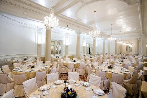 a banquet hall with tables and chairs and chandeliers at Hotel Carlton in Bilbao