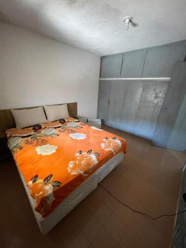 a bedroom with a bed with an orange blanket at MARVIR en Alvorada in Barra del Chuy
