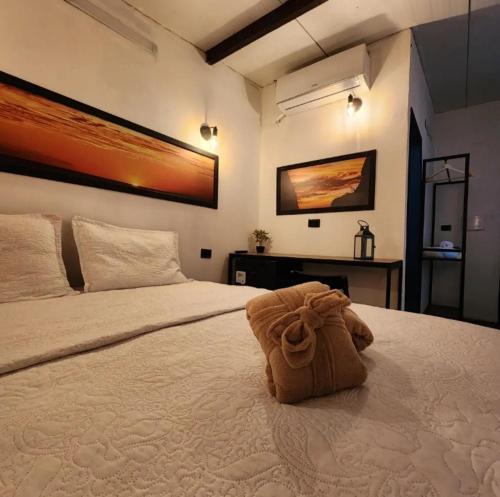 a large bed with a brown bag on top of it at Suítes Domo do Matto in Garanhuns
