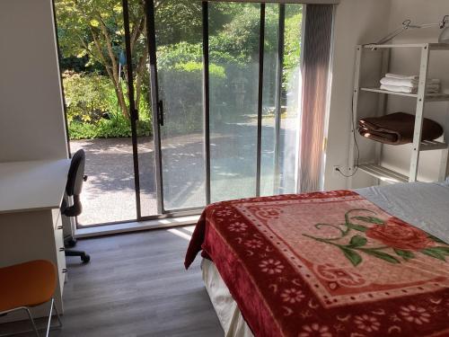 a bedroom with a bed and a large window at Garden room B in West Vancouver
