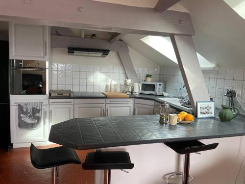 une cuisine avec un comptoir et des tabourets. dans l'établissement Saint Raphaël, Terrasse, superbe vue mer, à Saint-Raphaël