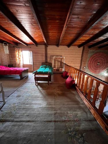 a living room with a bed and a wooden ceiling at Cabaña Bethsabet Cafayate Salta in Cafayate