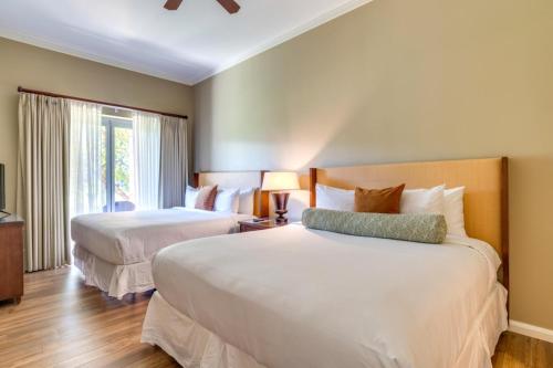 ein Hotelzimmer mit 2 Betten und einem Fenster in der Unterkunft K B M Resorts- HKK-104 Gorgeous resort view 2bed , 2ba with large lanai in Kaanapali