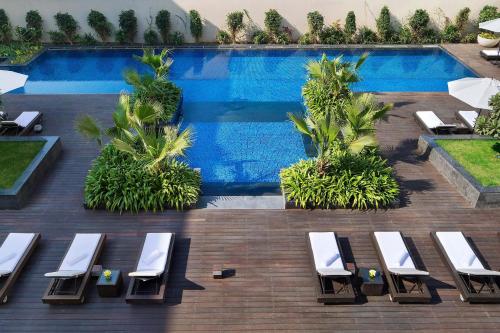 a swimming pool with chaise lounge chairs next to a resort at JW Marriott Hotel New Delhi Aerocity in New Delhi