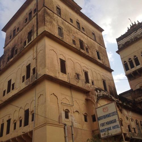 a tall building with a sign in front of it at Narayan Niwas Castle in Rāmgarh