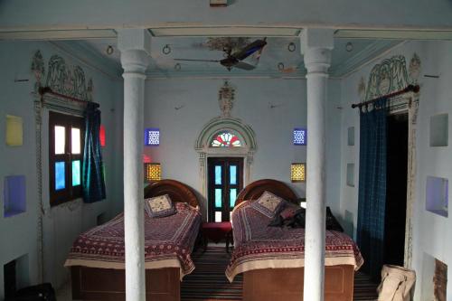 a bedroom with two beds and a window at Narayan Niwas Castle in Rāmgarh