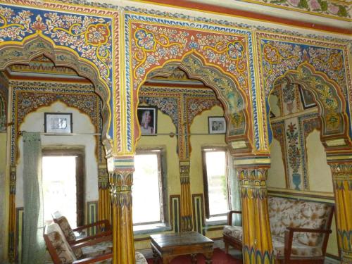 an ornate room with a large mirror in a building at Narayan Niwas Castle in Rāmgarh